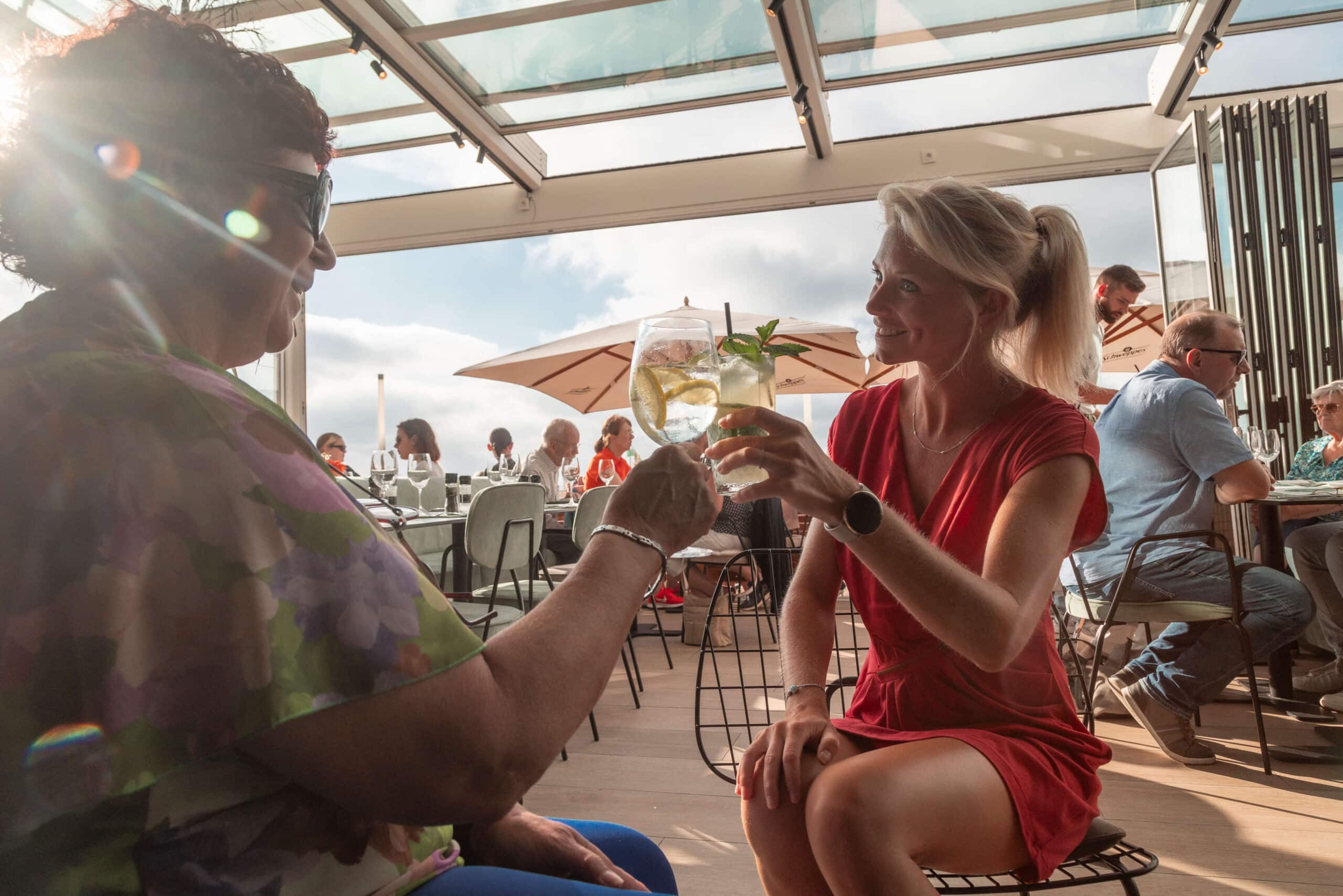 l'Apéro - vrouw die 'santé' doet op het terras